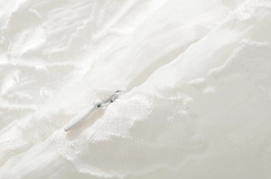 Gros plan détaillé de la fermeture éclair invisible et de la broderie sur la robe d'été blanche