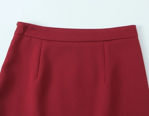 Close-up of a high-waisted burgundy skirt featuring an invisible zipper and fine darts