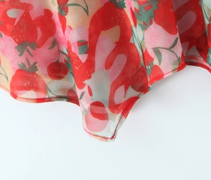 Close-up of strawberry and cherry print on soft chiffon fabric with fine hemmed edges