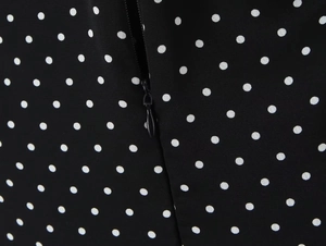 Close-up detail of invisible zipper on a black and white polka dot summer dress fabric
