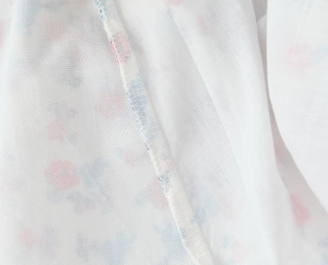Detail of overlock stitch on floral fabric with pink flower patterns on white base