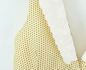 Detail of yellow polka dot dress with white embroidered lace Peter Pan collar