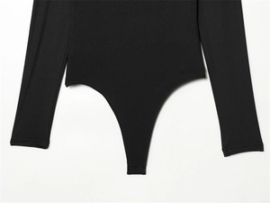Detailed close-up showing the high-cut thong bottom and stitching of the black bodysuit