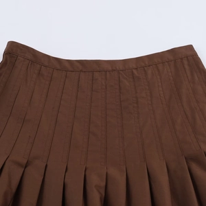 Detailed view of dark brown high-waisted pleated midi skirt fabric and fine stitching