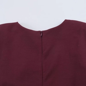 Detail of the invisible zipper closure on a wine red short sleeve dress neckline