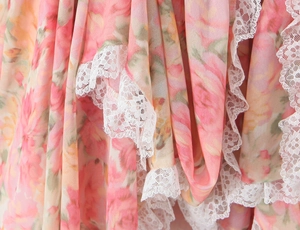 Gros plan sur tissu mousseline à fleurs avec dentelle blanche et volants délicats