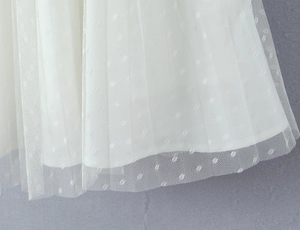 Detail of white mesh dress hem with fine polka dots and double layer lining texture