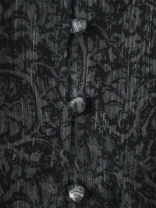 Close-up of dark floral fabric with metallic stripes and fabric-covered buttons detail