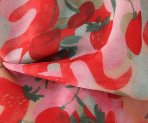 Detailed view of lightweight fabric featuring strawberry prints and wavy geometric patterns