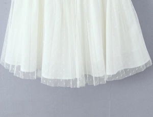 Detail of white mesh summer dress with micro polka dots and tiered ruffle layers