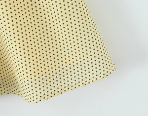 Detail view of yellow polka dot dress hem with high-quality single-needle stitching