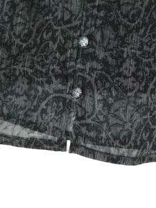 Detail of paisley patterned fabric with metallic stripes and vintage silver buttons