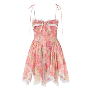 Détail d'une robe fleurie rose avec bordure en dentelle, nœud et ourlet asymétrique