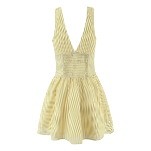 Detailed close-up of smocked waist and black polka dot pattern on yellow summer dress