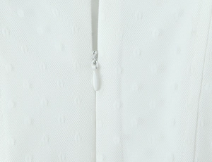 Detailed view of the invisible zipper on white mesh fabric with dot patterns