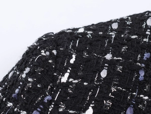 Macro shot of black tweed fabric with silver metallic threads and bouclé texture