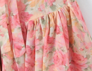 Détails de la robe en mousseline florale montrant les plis à la taille et les coutures