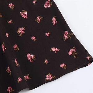 Vue détaillée de l'ourlet de robe noire avec imprimé roses roses et coutures nettes