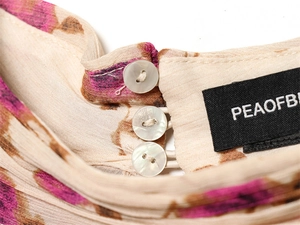 Macro view of pearlescent shell buttons and floral chiffon fabric on shirt neckline