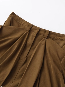 Macro view of brown cotton skirt waist with tiered pleats and belt loops detail