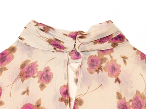Detail of floral chiffon blouse featuring a pleated high neck and keyhole cutout design
