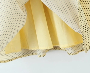 Detail of light yellow polka dot dress with double-layer fabric and neat hem stitching