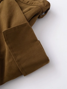 Detail view of tobacco brown cotton twill fabric showing precision stitching on skirt