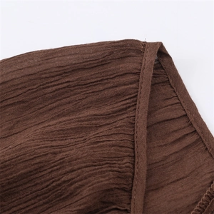 Macro shot of dark brown crinkle fabric showing detailed stitching and texture