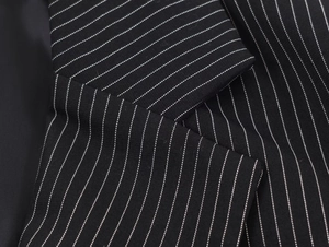 Close-up of pinstripe suit collar showing premium twill fabric and expert stitching