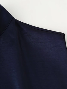 Detail of dark blue dress showing high-quality stitching and satin fabric texture
