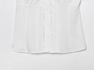 Detailed view of the ruffle trim design and white buttons on a stylish cotton shirt