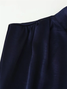 Detailed view of the dark blue satin dress shoulder pleats and delicate collar stitching