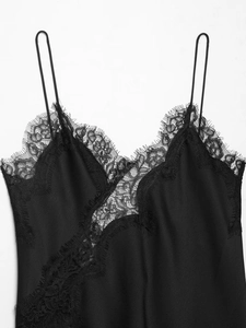Détail du col en V avec dentelle de cils délicate sur un caraco en satin noir élégant