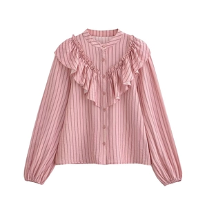 Detail of pink striped shirt showing vertical patterns and elegant ruffle decorations