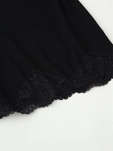 Gros plan sur la dentelle florale noire et le tissu lisse sur l'ourlet de la robe