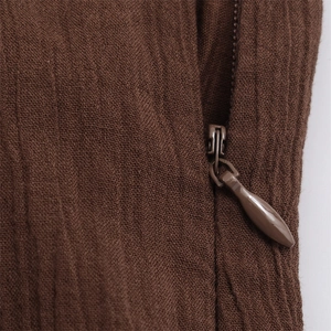 Close-up of a brown sheer mesh dress featuring a hidden zipper with vertical texture