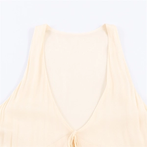 Detail of elegant cream chiffon dress showing delicate deep V-neckline and fabric texture