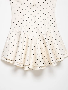 Detail of slim fit polka dot dress featuring hidden back zipper and ruffled mermaid hem