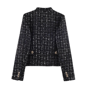Detail of tweed blazer back featuring textured black fabric and vintage gold buttons