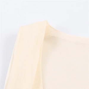 Close-up of light beige chiffon fabric showing detailed stitching and textured material