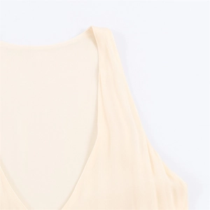 Detailed macro view of light beige V-neck sleeveless dress with premium fabric texture