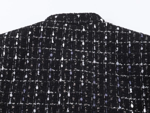 Macro detail of metallic textured tweed jacket fabric with purple and silver thread weave