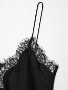 Détail en gros plan de la dentelle florale et des fines bretelles sur caraco noir