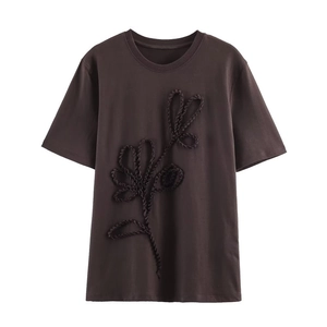 Close-up of the dark brown T-shirt showing detailed 3D pleated floral pattern texture