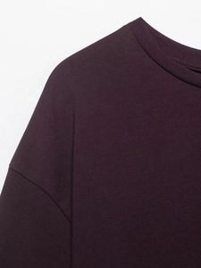Dettaglio del girocollo a costine e cucitura della spalla su T-shirt viola con pizzo