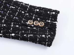 Detail of black tweed sleeve featuring vintage metal buttons with crest engraving