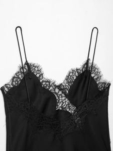 Détail d'un caraco en satin noir avec bordure en dentelle cil et fines bretelles