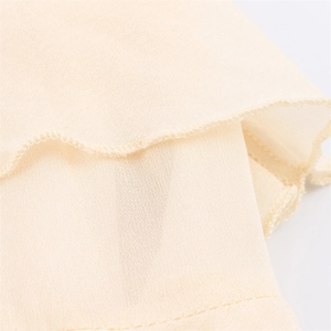 Close-up of fine overlock stitching and lightweight semi-sheer cream chiffon fabric