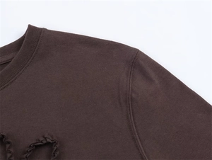 Detail of the crew neck and ruffled shoulder trim on this dark brown casual cotton T-shirt