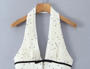Détail de la robe licou à pois avec décolleté en V plissé et nœud en velours élégant